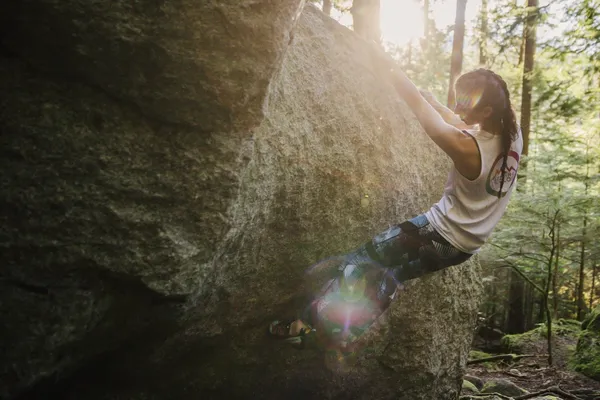A person scaling a large rock or boulder