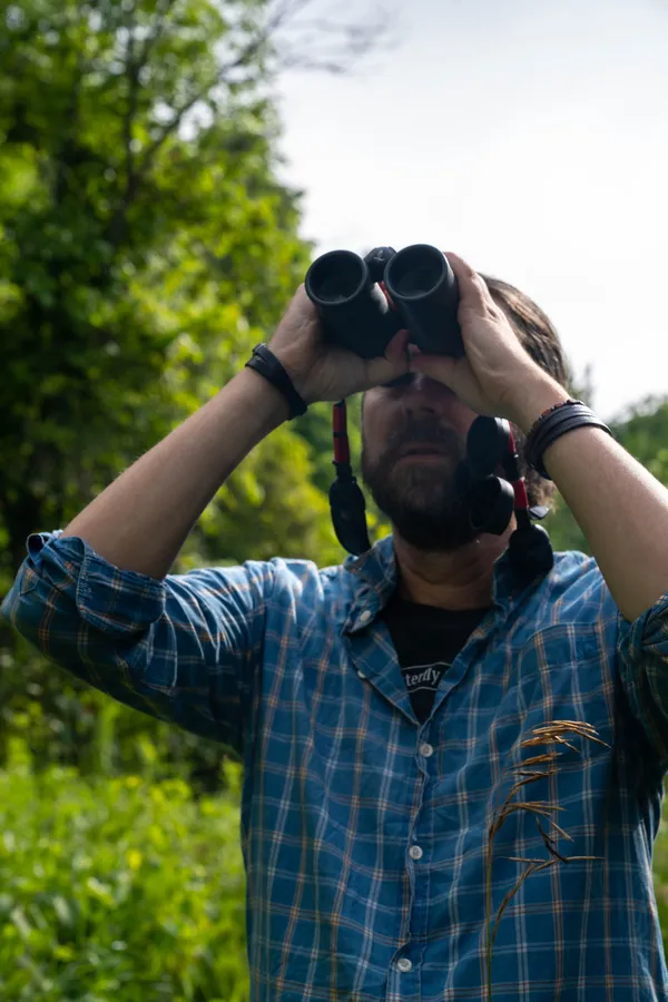 A man looking through binoculars
