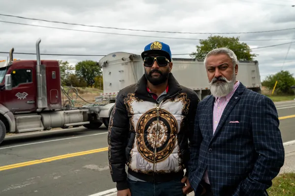 Two men with a truck in the background